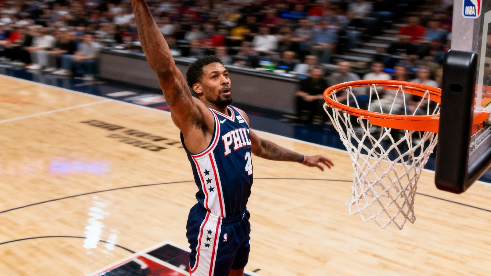 NBA篮球赛场上球员飞身扣篮的精彩瞬间抓拍，橙色篮球悬于空中